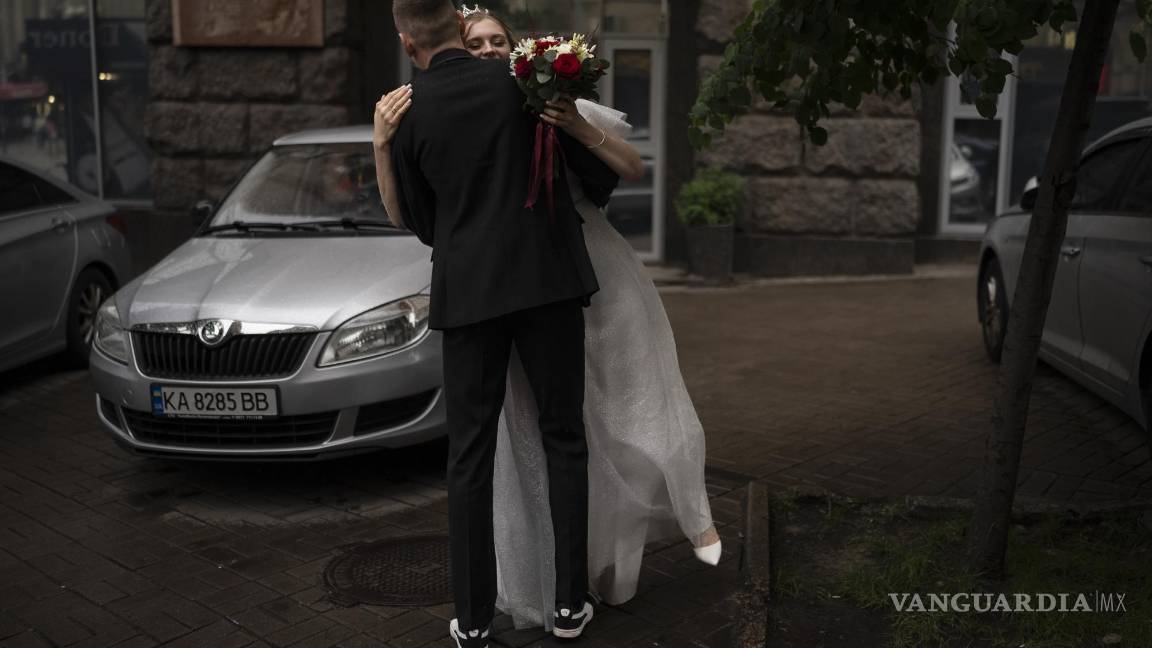 $!Los recién casados, Nikita Timkov, de 25 años, y su novia, Tamika Timkova, de 23, bailanen la calle mientras esperan a su conductor en Kiev, Ucrania.