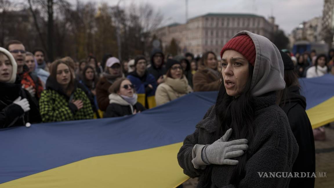 $!Una mujer canta el himno nacional de Ucrania durante una manifestación en el centro de Kiev.