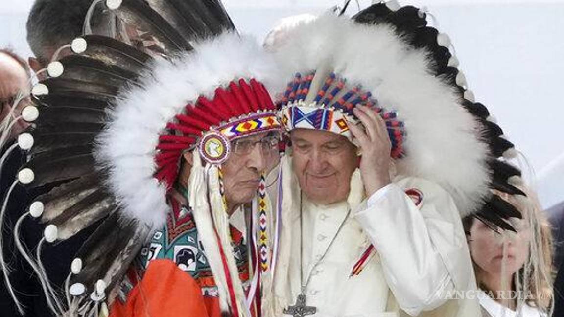 $!El papa Francisco se pone un tocado indígena en una reunión con las comunidades indígenas en la iglesia católica de Nuestra Señora de los Siete Dolores en Maskwacis, cerca de Edmonton, Canadá