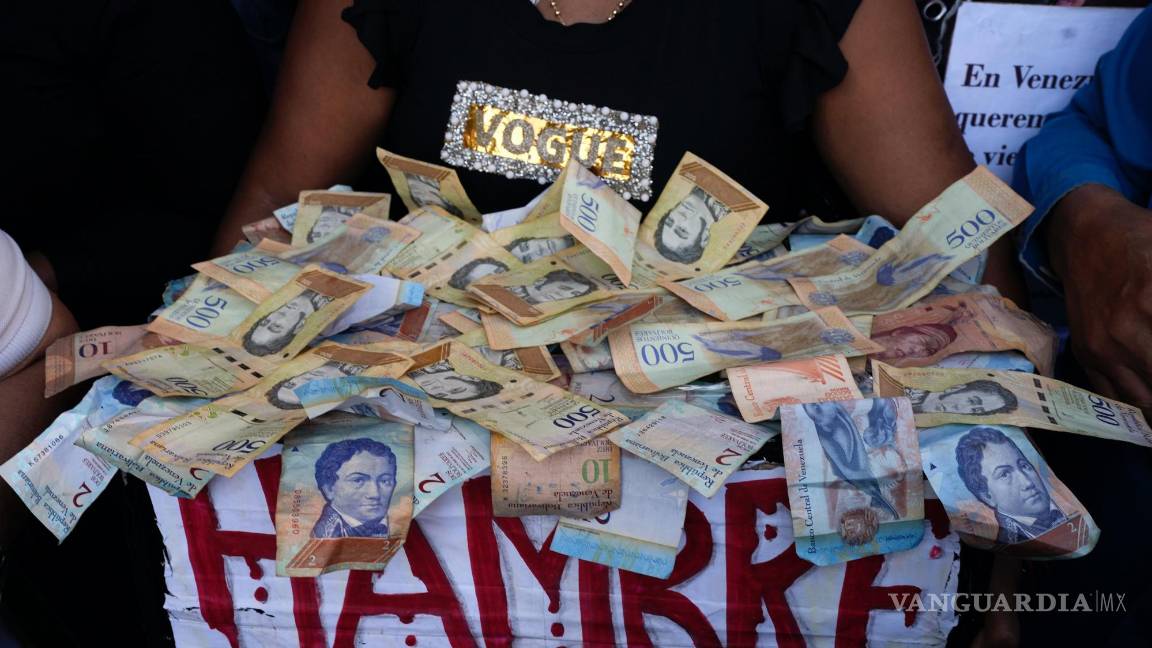 $!Un manifestante lleva una caja con la palabra hambre y billetes de bolívares, en una protesta para reclamar mayores salarios y beneficios en Caracas, Venezuela.