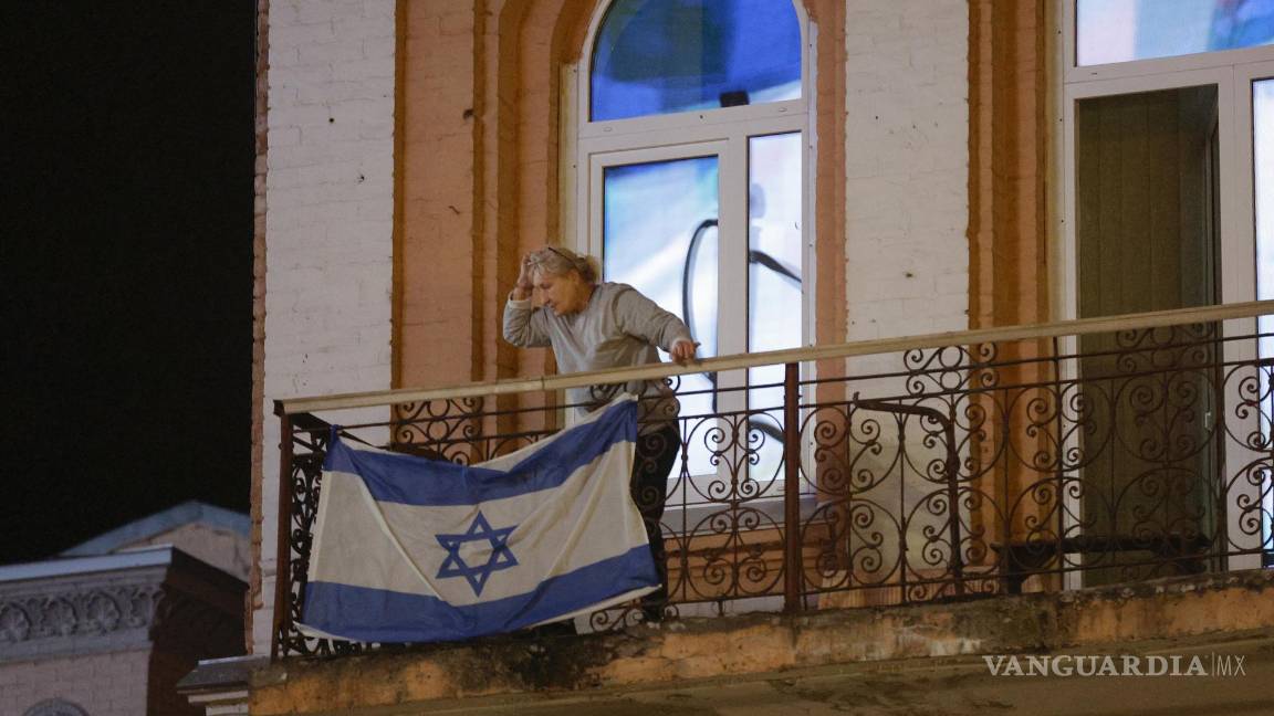 $!Una anciana cuelga una bandera nacional israelí en su balcón en el centro de Kiev, Ucrania.