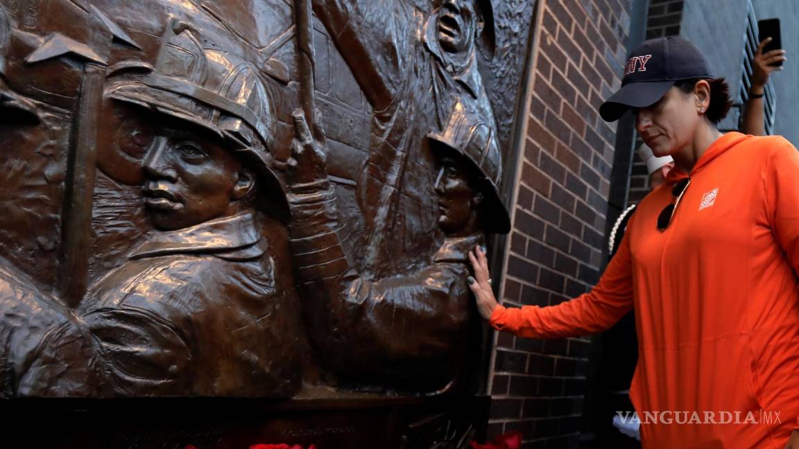 $!Una mujer toca el socorro del bombero en la ceremonia Tunnel to Towers para conmemorar a todos los que murieron en los ataques terroristas del 11 de septiembre de 2001 en la estación de bomberos Ladder 10 en el bajo Manhattan, en Nueva York, Nueva York. EFE/EPA/Peter Foley