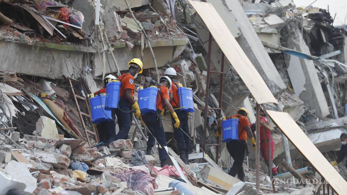 $!Miembros de un equipo de rescate de Myanmar rocían agua en la derrumbada Sky Villa en Mandalay, Myanmar.