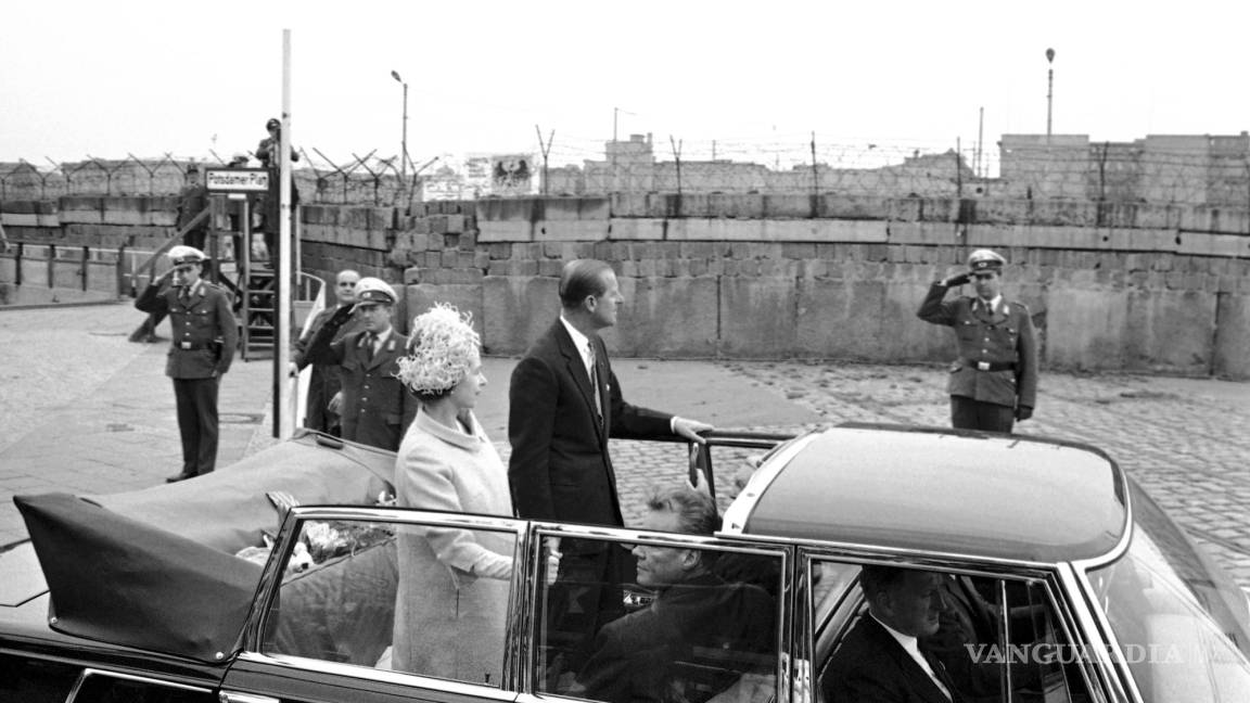 $!La reina Isabel II y el príncipe Felipe pasan junto al muro que divide Alemania Oriental y Occidental, en un recorrido por Berlín Occidental, el 27 de mayo de 1965.