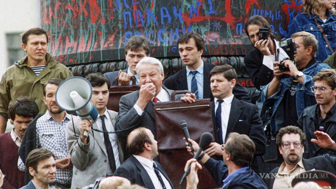 $!En esta fotografía de archivo del viernes 23 de agosto de 1991, el presidente de la Federación de Rusia, Boris Yeltsin, en el centro, usa un megáfono para dirigirse a una multitud que se reunió en la plaza Dzerzhinsky para celebrar el derrumbe de la estatua del fundador de la KGB, Felix Dzerzhinsky, en Moscú, Rusia. AP/Alexander Zemlianichenko