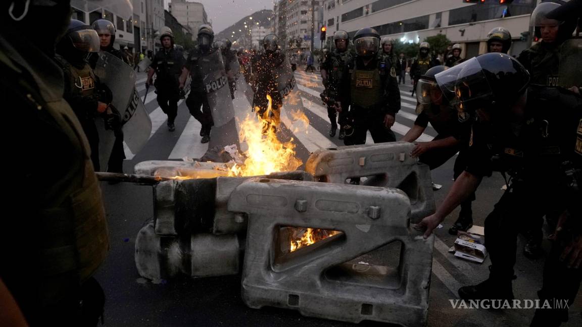 $!La policía desmantela una barricada en llamas levantada por partidarios del derrocado presidente Pedro Castillo durante enfrentamientos con la policía.