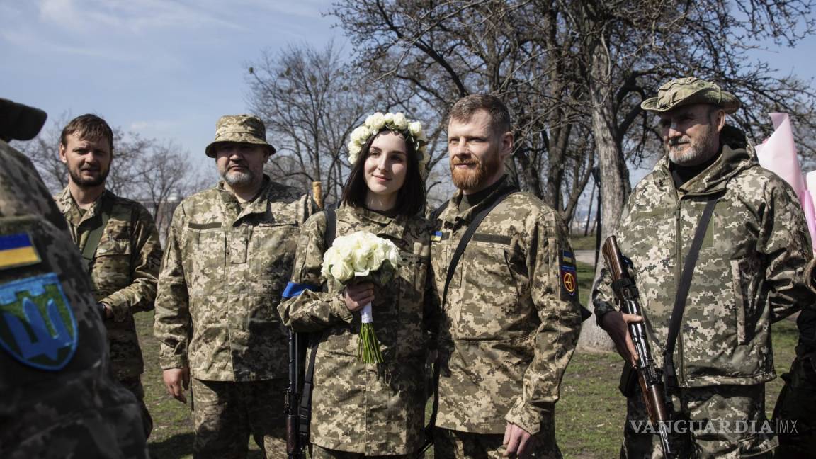 $!Los miembros de la Defensa Territorial de Kiev, Anastasiia (24) y Viacheslav (43) celebran su boda bajo las normas de la ley marcial en Kiev, Ucrania.
