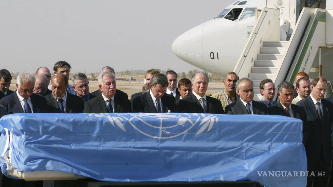 $!El administrador estadounidense en Irak, Paul Bremer, cuarto de izquierda a derecha, junto con funcionarios iraquíes y de la ONU, rinde homenaje ante el féretro de Sergio Vieira de Mello, envuelto en una bandera de la ONU.