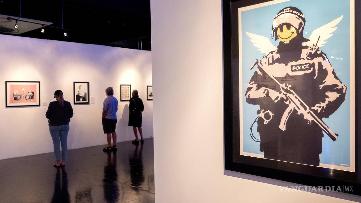 $!Personas cerca de la obra de arte ‘Flying Copper’ (R) mientras visitan la exposición ‘The Art of Banksy: Without Limits’. EFE/EPA/Cristobal Herrera-Ulashkevich