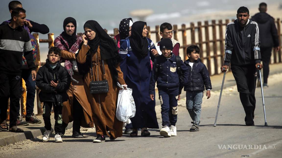 $!Palestinos caminan por la carretera Al Rashid después de cruzar desde el norte de la Franja de Gaza hacia el sur de la ciudad de Gaza, 25 de febrero de 2024.