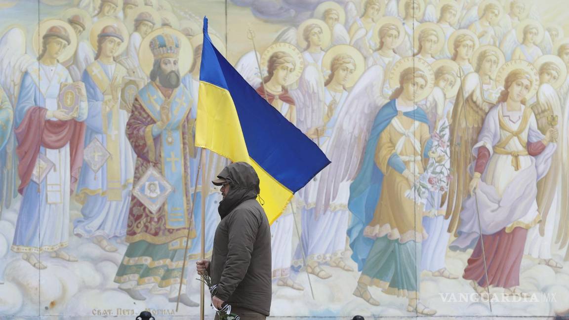 $!Un hombre con una bandera ucraniana en el funeral en la Catedral de San Mykhailivsky en Kiev de la difunta médica de combate Maria-Khrystyna Dvoinik.
