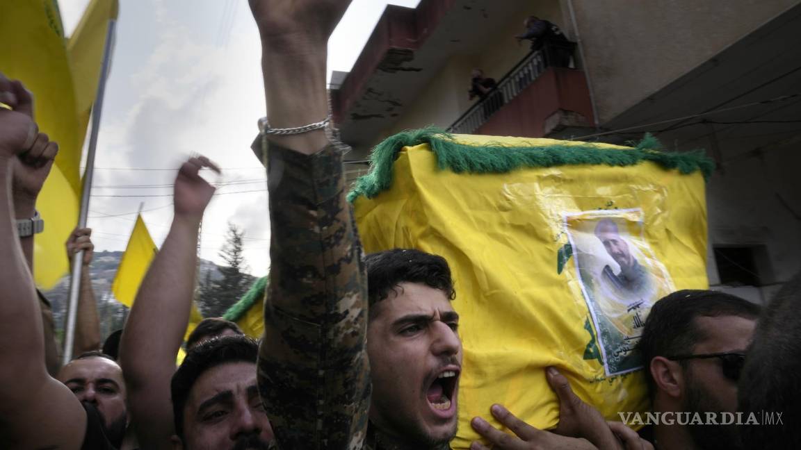 $!Un combatiente de Hezbollah carga el ataúd de uno de sus compañeros que murió por artillería israelí, mientras grita consignas durante una procesión fúnebre, el martes 10 de octubre de 2023, en el poblado de Khirbet Selm, en el sur de Líbano. El grupo respaldado por Irán anunció el lunes por la noche que tres de sus elementos murieron luego de un intenso bombardeo israelí contra distintos poblados en el sur de Líbano. (AP Foto/Hussein Malla)