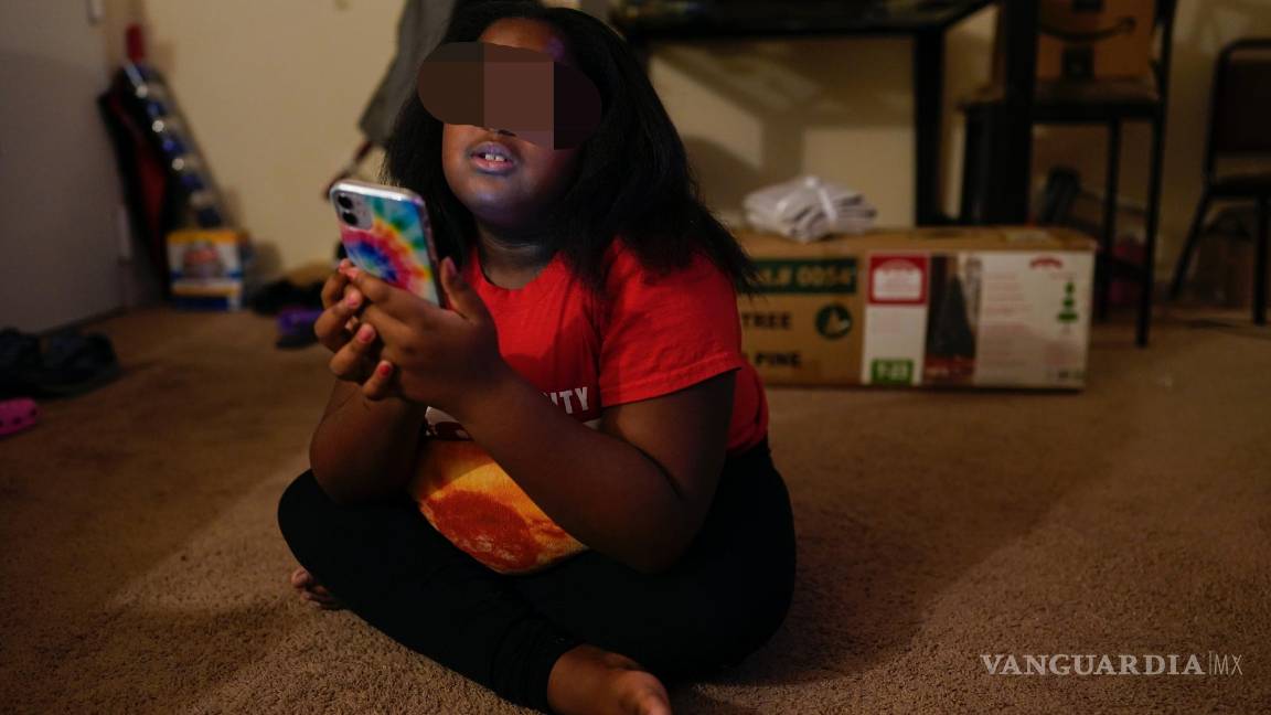 $!Brooklynn Chiles, de ocho años, juega con su teléfono en su casa en Washington el 9 de enero del 2022. La niña contrajo tres veces el COVID-19.