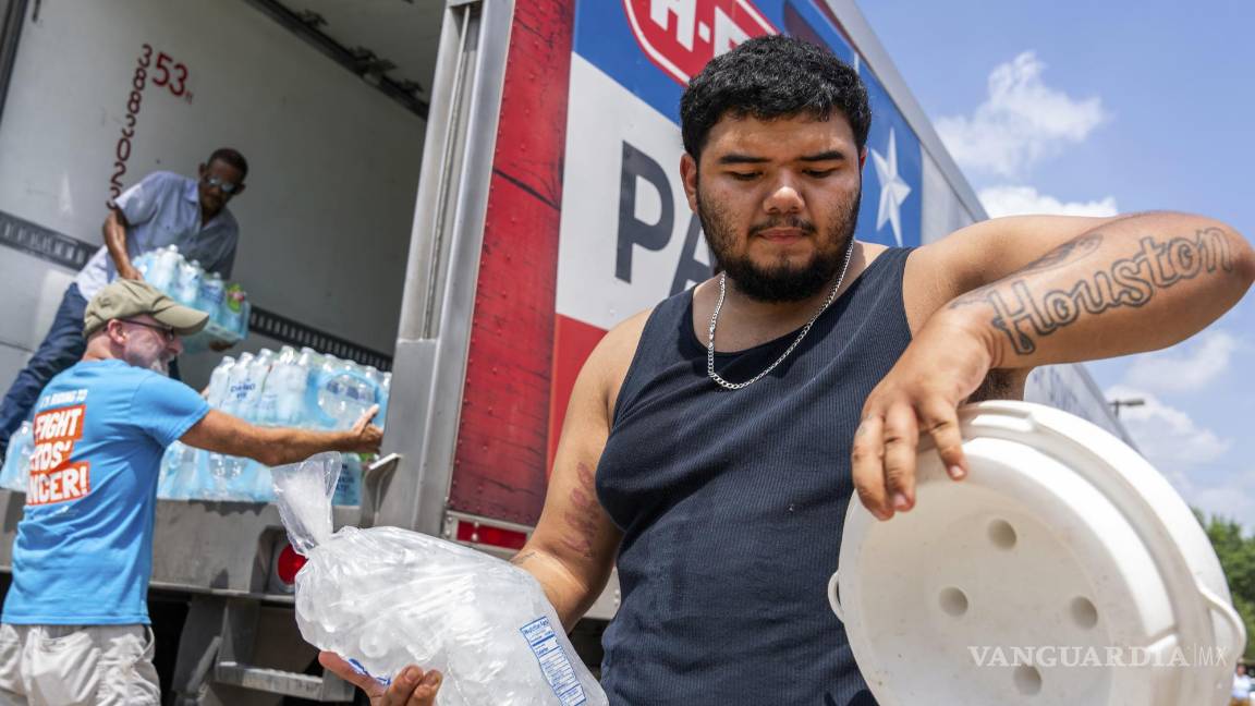 $!Daniel Valdez coloca una bolsa de hielo en una hielera mientras los voluntarios de Memorial Assistance Ministries distribuyen agua y hielo en Houston.
