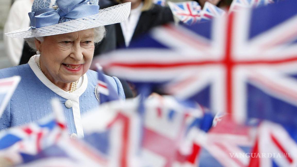 $!Imagen del martes 21 de junio de 2011, escolares ondean banderas cuando la reina Isabel II de Gran Bretaña sale de la catedral de San Pablo en Londres.