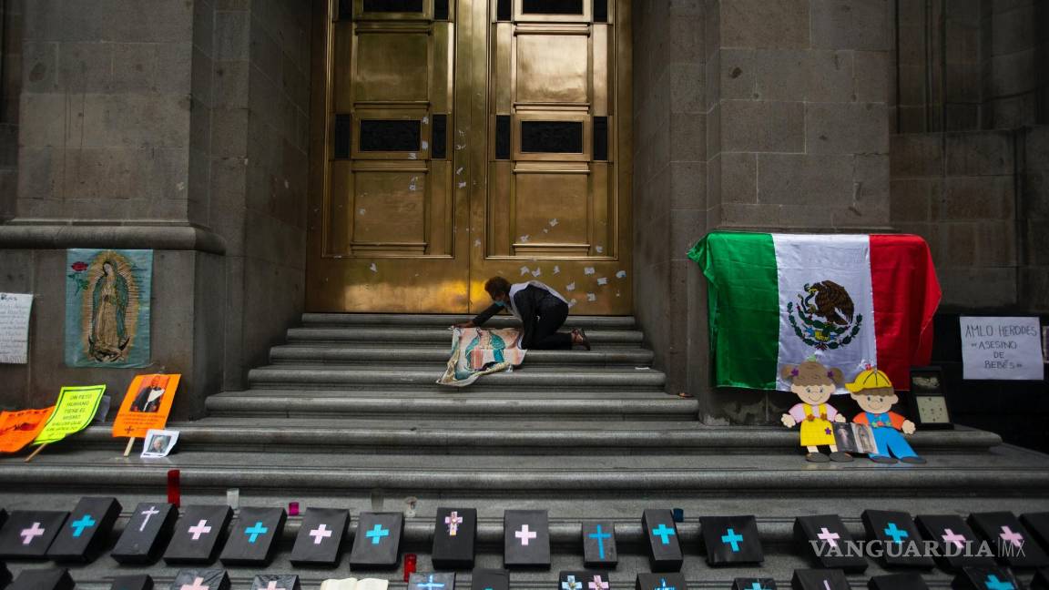 $!Activista contra el aborto coloca un panel de tela de Nuestra Señora de Guadalupe junto a pequeños ataúdes simulados en la entrada de la Corte Suprema.