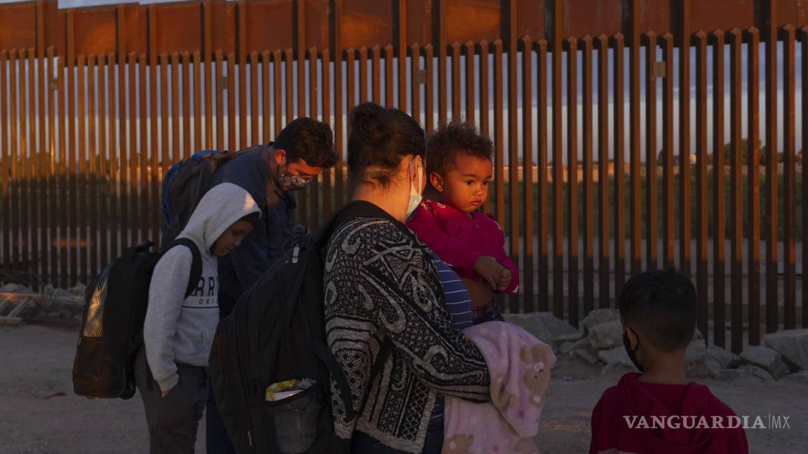 $!Migrantes esperan a ser procesados por agentes fronterizos de EU, tras pasar por una brecha en el muro, en Yuma, Arizona.