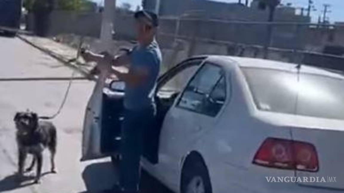 $!El conductor detiene su marcha y baja del auto, mientras sigue sosteniendo la correa de su perrito.