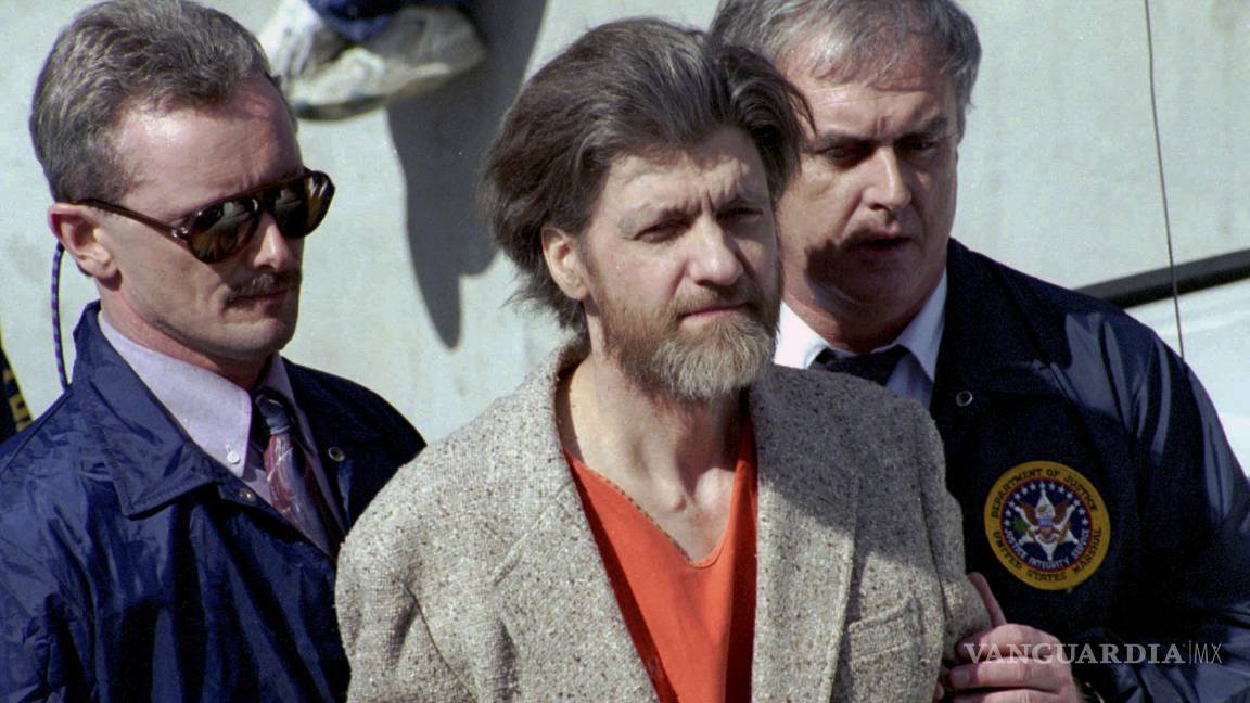 $!Theodore Ted Kaczynski es escoltado a su auto afuera de una corte federal en Helena, Montana, el 4 de abril de 1996.