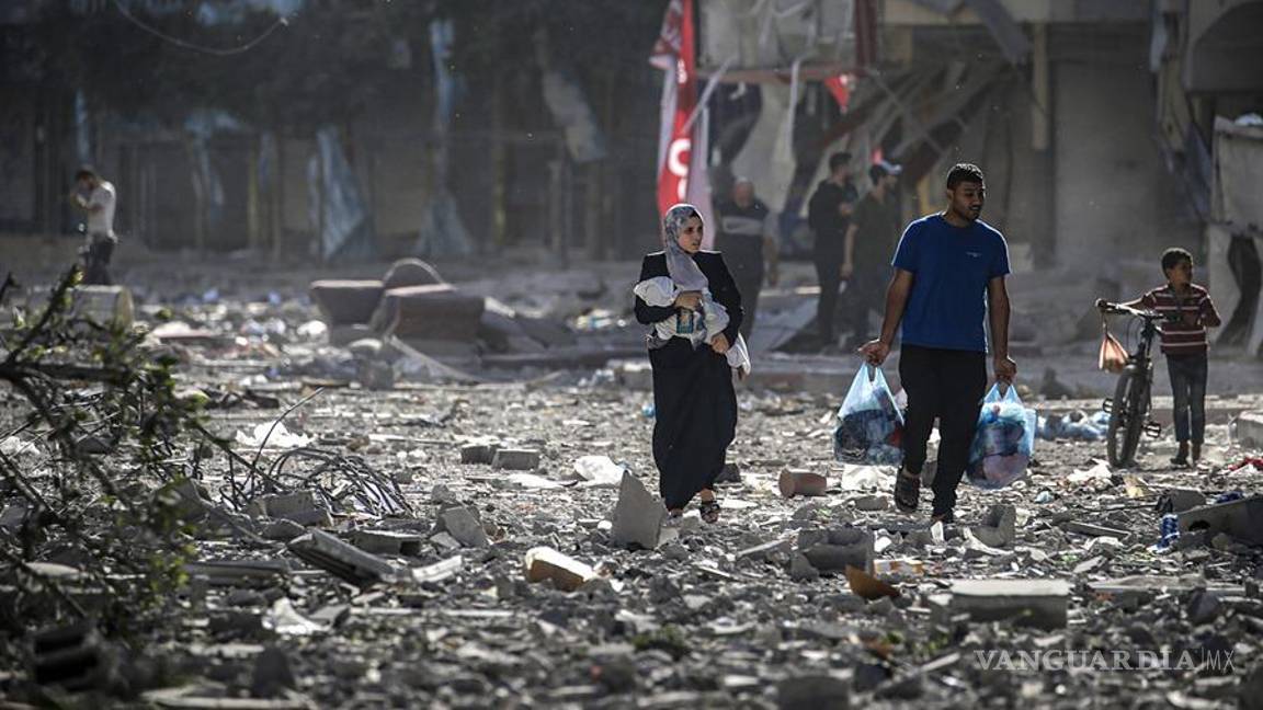 $!Una familia palestina se abre paso entre los escombros de los edificios alcanzados en un bombardeo israelí sobre el barrio de Tel al-Hawa, en Ciudad de Gaza.