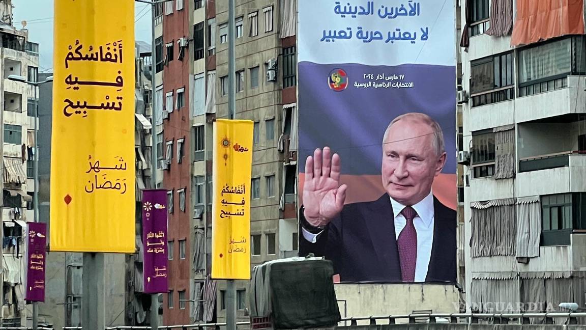 $!Una camioneta frente a un cartel publicitario de las próximas elecciones presidenciales rusas con una imagen de Vladimir Putin, en Beirut, Líbano.