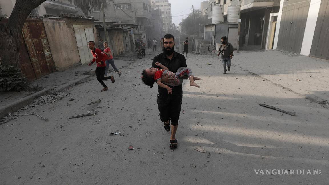 $!Un palestino carga a una niña herida tras los ataques aéreos israelíes en el norte de Gaza.
