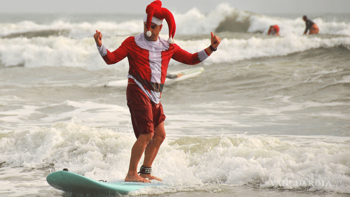Personas disfrazadas de Santa Claus surfean en Florida