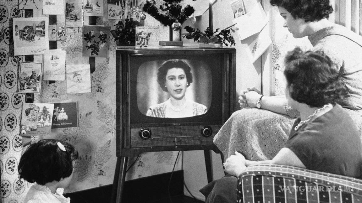 $!Una familia de Londres mira a la reina Isabel II en una pantalla de televisión durante el primer discurso de Navidad de la reina el 26 de diciembre de 1957. AP