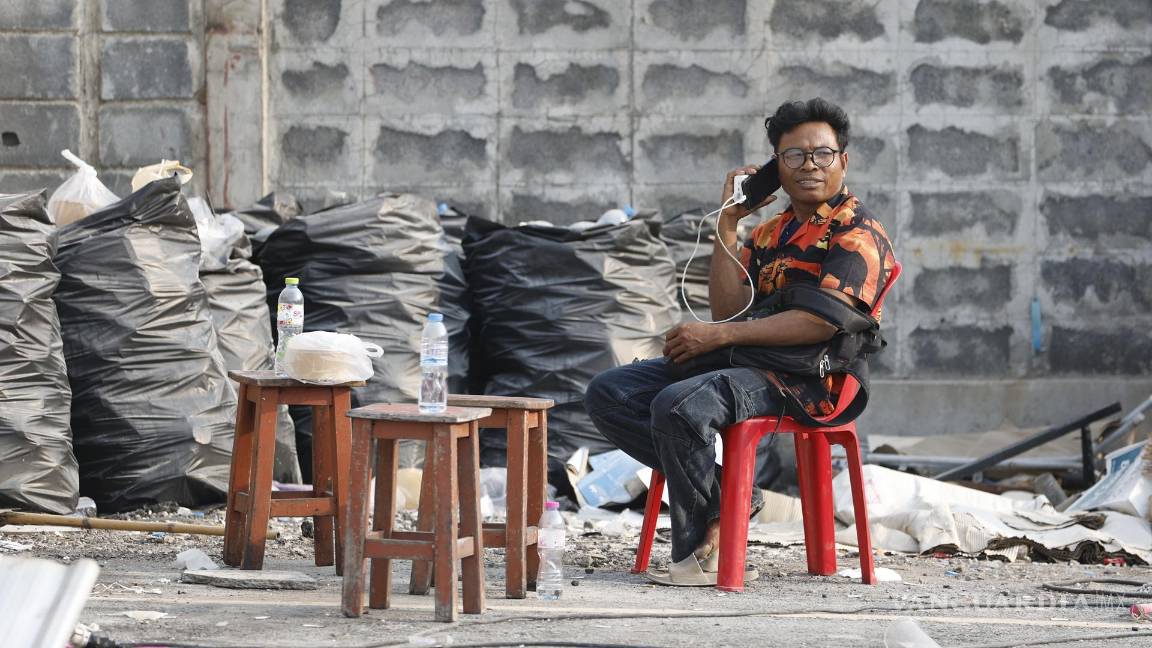 $!Un familiar espera a sus familiares desaparecidos durante una operación de búsqueda de sobrevivientes en el lugar de un edificio derrumbado en Bangkok.