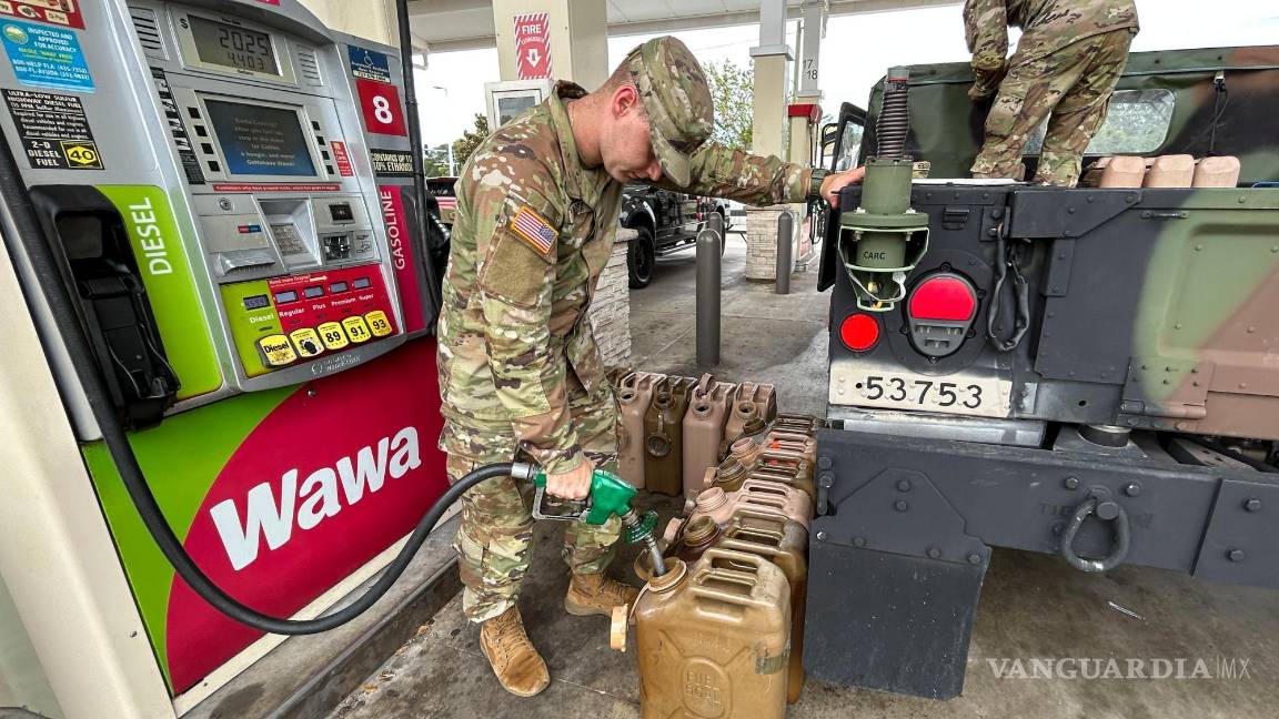$!Miembros de la Guardia Nacional, que pidieron no ser identificados, llenan bidones de gasolina en una gasolinera de Wawa en Pinellas Park, Florida.