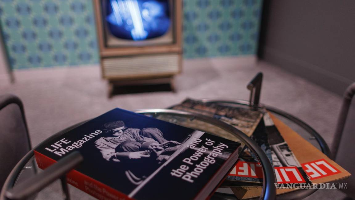 $!Copias de la revista Life y el catálogo de la exposición se exhiben en una mesa frente a un televisor que muestra el alunizaje de 1969.