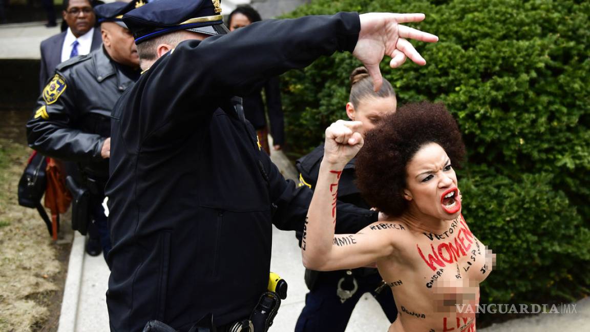 Manifestante 'topless' encara a Bill Cosby al empezar su juicio