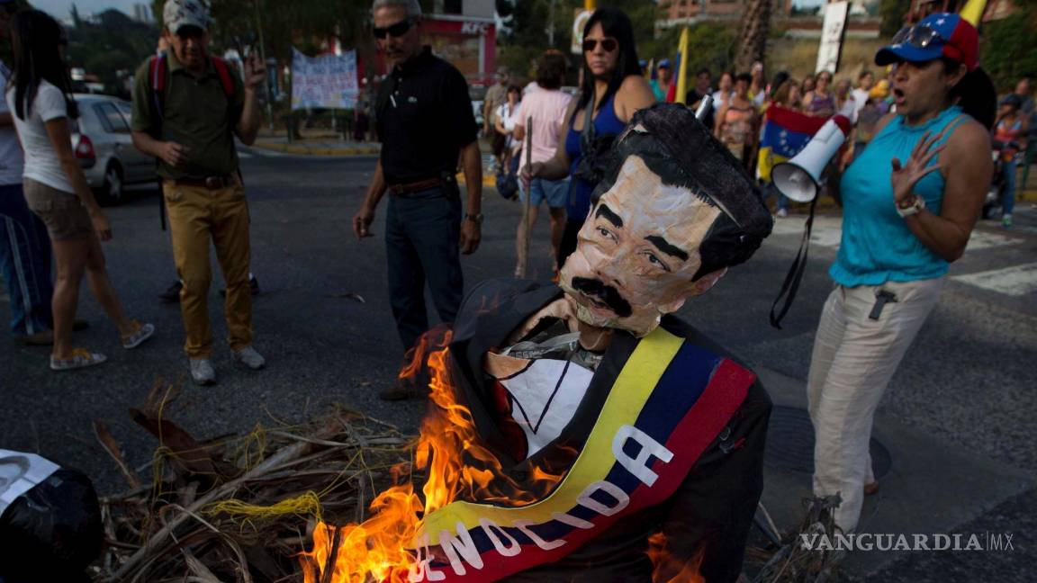 $!Ciudadanos opositores queman una figura con la imagen del presidente de Venezuela, Nicolás Maduro, en Caracas, Venezuela, el 20 de abril de 2014.