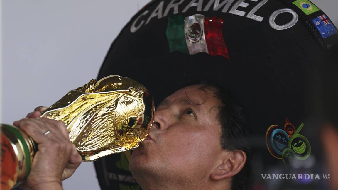 $!Héctor Chávez, hincha de la selección de México conocido como Caramelo besa una réplica de la Copa Mundial en Iztapalapa, Ciudad de México.