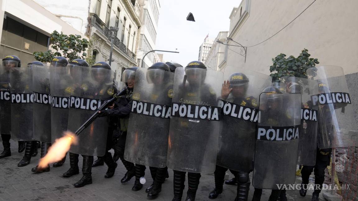 $!Un policía con equipamiento antimotines dispara su escopeta para dispersar a los manifestantes opositores que protestan contra la presidenta peruana.