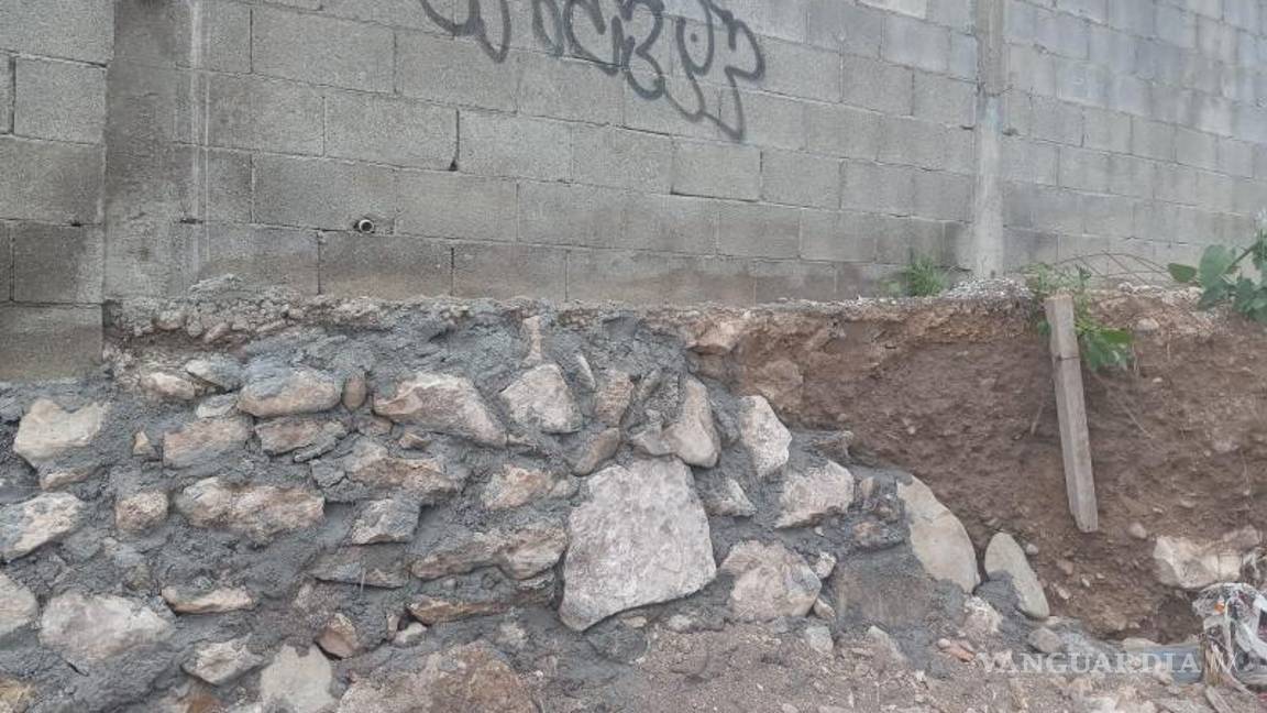 $!Barda caída en predio vecino por socavón generado cerca de obras inconclusas.