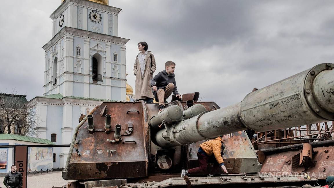 $!La gente se sube al casco de un tanque ruso destruido en la plaza Mykhailivska, en las afueras del Monasterio de las Cúpulas Doradas de San Miguel en Kiev.