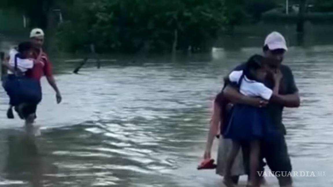 Estos niños y sus papás cruzan un río desbordado para llegar a la escuela