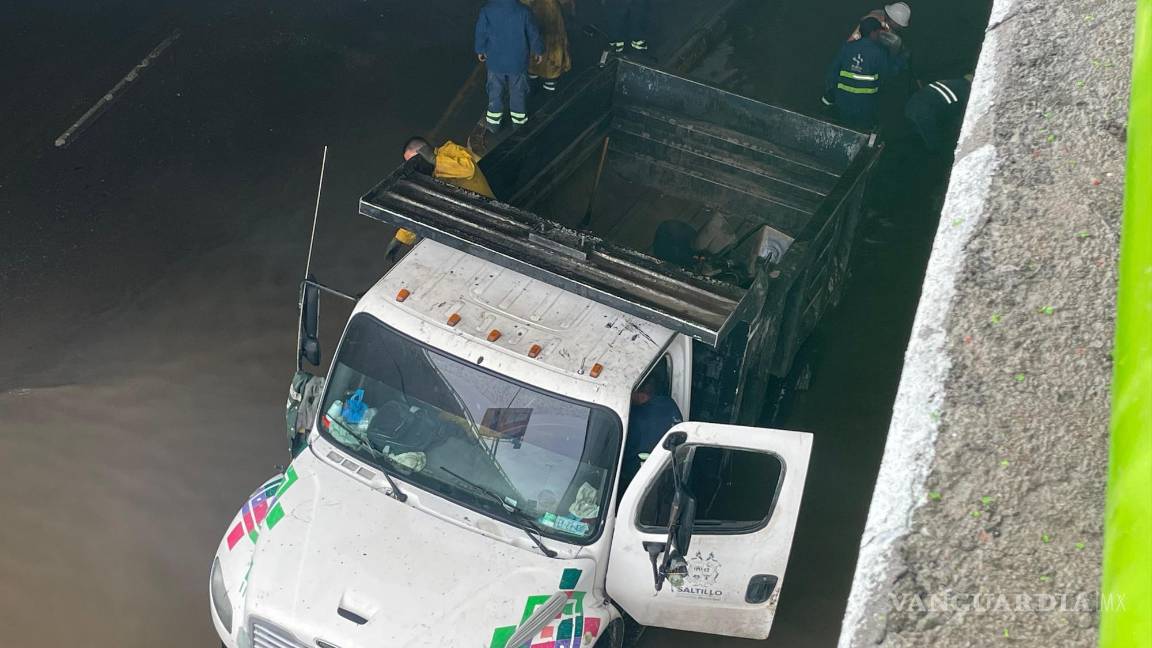 $!Equipos de mantenimiento del municipio intervinieron en el paso a desnivel inundado para despejar las rejillas pluviales bloqueadas.