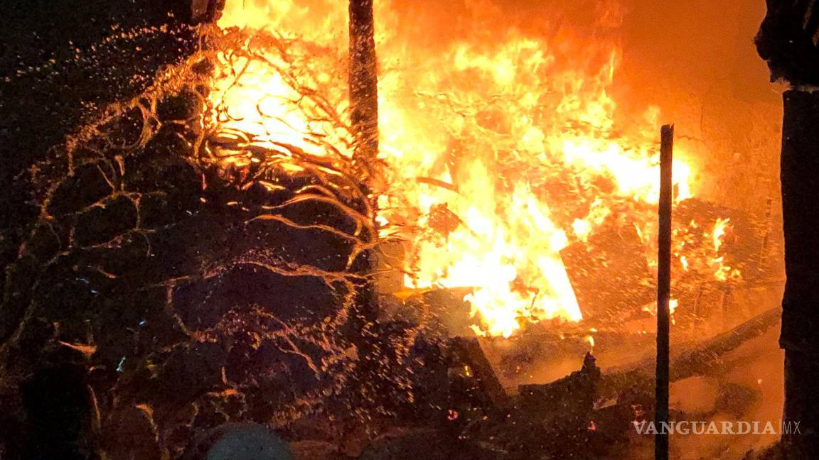 $!A cubetazos, los vecinos combatían el fuego.
