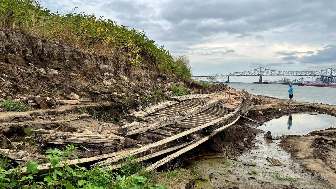 $!Un hombre que camina a lo largo del río Mississippi en Baton Rouge, Luisiana, se detiene para mirar un naufragio revelado por el bajo nivel del agua.