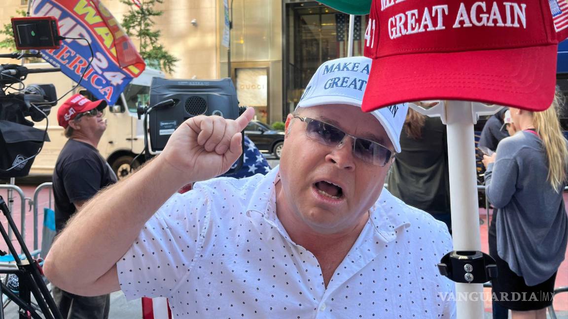 $!Un seguidor de Donald Trump grita consignas frente a una cámara mientras sostiene una gorra de 'Haz a los Estados Unidos grande otra vez' en Nueva York.