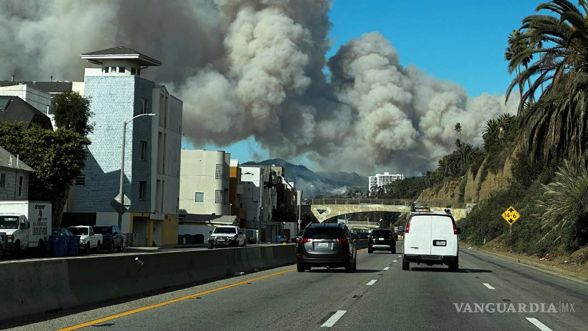 $!El humo denso de un incendio forestal en Pacific Palisades se eleva sobre la Pacific Coast Highway en Santa Mónica, California, el martes 7 de enero de 2025.