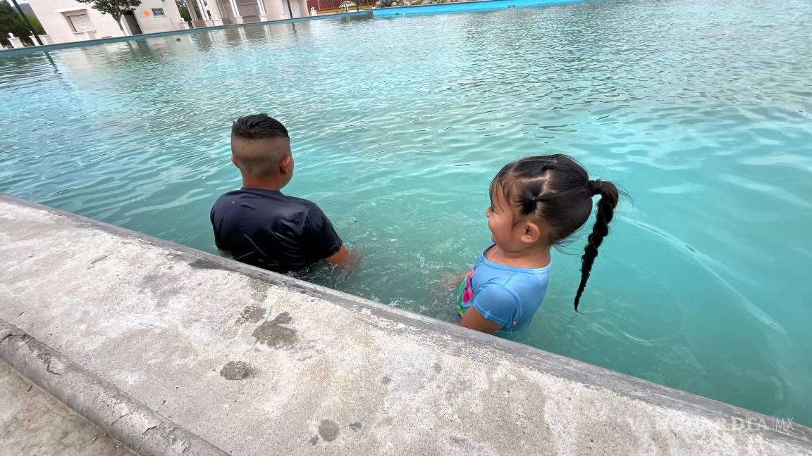 $!Algunas personas optaron por refrescarse en la fuente pública frente al parque.