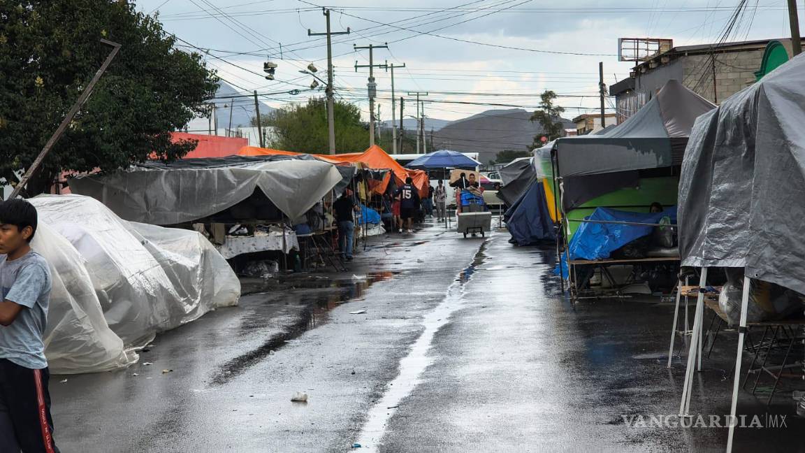 $!Debido a la sorpresiva lluvia, los puesteros del mercado de la Bellavista tuvieron que levantar su mercancía.