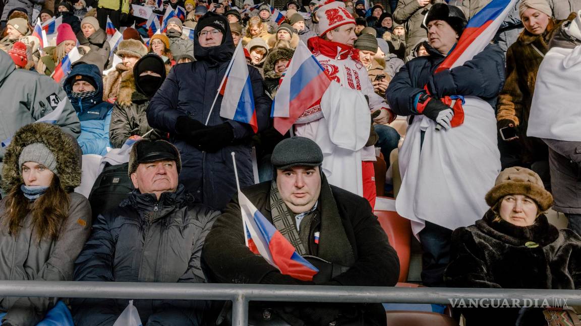 $!Personas en el evento llamado “Gloria a los defensores de la patria” escuchan el discurso del presidente ruso Vladímir Putin en el estadio Luzhniki de Moscú.