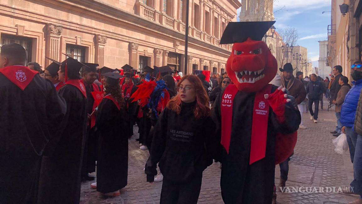 $!Alumnos de la Universidad Carolina ataviados con togas y birretes negros, listos para la procesión de graduación en el Paseo Capital.