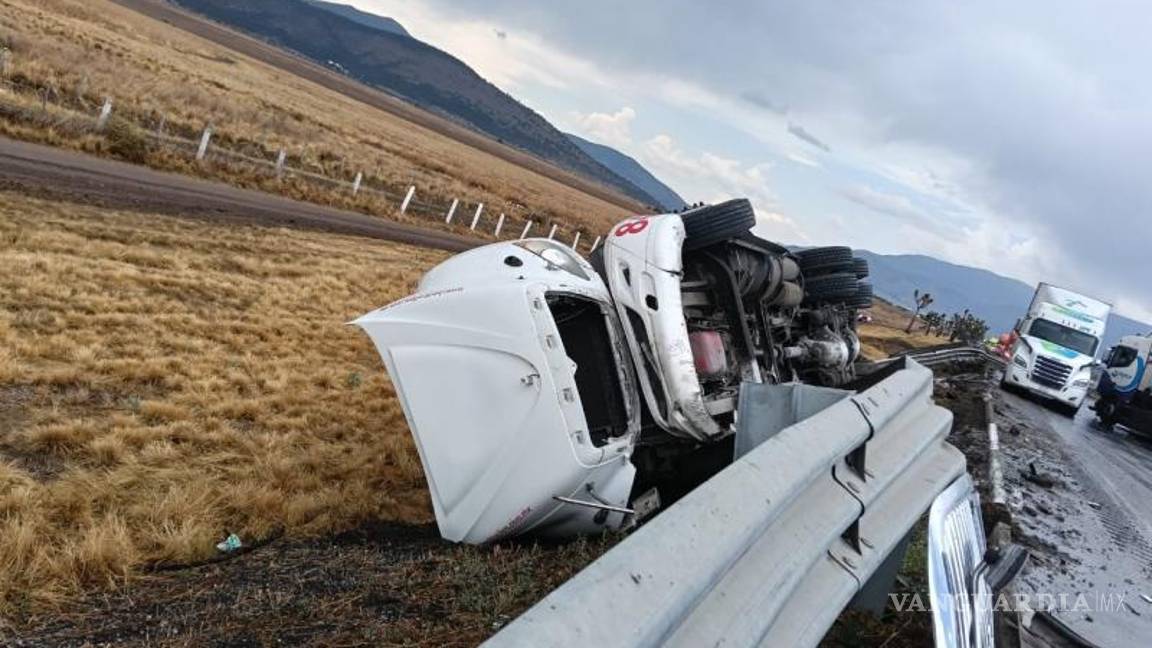 $!Uno de los tráileres involucrados quedó volcado fuera de la carpeta asfáltica, mientras continuaban las maniobras para su levantamiento.
