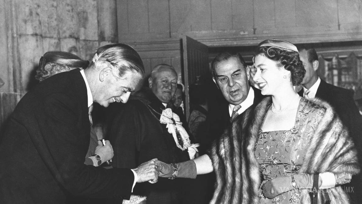 $!15 de mayo de 1956, el primer ministro británico Anthony Eden hace una reverencia a la reina Isabel II a su llegada al Guildhall de Londres.