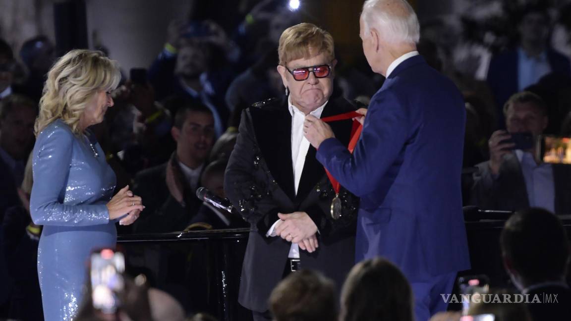 $!El presidente de los Estados Unidos, Joe Biden (derecha), entrega al cantante británico Elton John (centro) la Medalla Nacional de Humanidades.